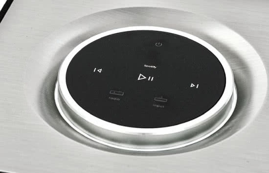 Do obsługi urządzenia służy okrągły panel dotykowy, który jest otoczony metalowym pierścieniem do regulacji siły głosu.