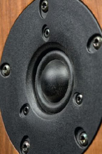 Znany z wielu konstrukcji ESA, i nie tylko, kopułkowo-
pierścieniowy głośnik wysokotonowy jest
teraz kupowany w Scan-Speaku i pojawia się tutaj
w "mocniejszej" wersji - z podwójnym układem
magnetycznym i komorą wytłumiającą. Można spotkać
wiele jego odmian, ale układ drgający jest zwykle taki
sam - 25-mm tekstylna kopułka, wokół której widać
pierścień pełniący zarówno rolę zawieszenia, jak
i części membrany promieniującej najwyższe częstotliwości
(ze względu na niewielką odległość od cewki,
mocowanej na przełomie kopułki i pierścienia).