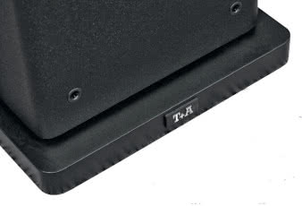 Obudowa jest
technicznie solidna,
estetycznie skromna, ale ma
kilka "smaczków" - zaokrąglone
pionowe krawędzie i małą dylatację na
połączeniu z cokołem, bardzo praktycznym,
bo nieco większym niż podstawa samej skrzynki,
a więc poprawiającym stabilność, a nie tylko wygląd.