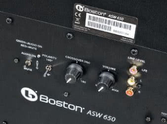 Boston ASW 650 prezentuje dość typowy dla współczesnych
subwooferów - ani nie skrajnie ograniczony,
ani nie najbardziej rozbudowany - zestaw
regulacyjno-przyłączeniowy. Sygnał możemy dostarczyć
albo do stereofonicznej pary RCA, albo do
pojedynczego gniazda, oznaczonego LFE (wówczas
nie powinien być filtrowany przez układy wzmacniacza);
regulacje składają się z dwóch pokręteł
- wzmocnienia i górnej częstotliwości podziału oraz
jednego hebelkowego, dwupozycyjnego przełącznika
fazy. Drugim przełącznikiem możemy wyciszyć
subwoofer, bez wyłączania zasilania.