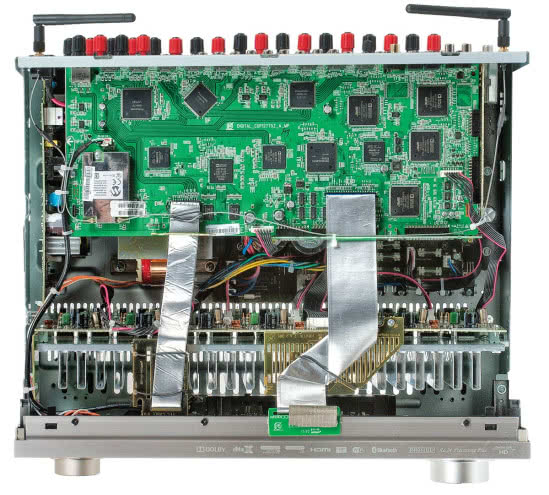 Typowa "piętrowa" konstrukcja amplitunera AV. Tranzystory kanałów mocy znalazły się w komplecie na jednym dużym radiatorze zamocowanym wzdłuż przedniego panelu.